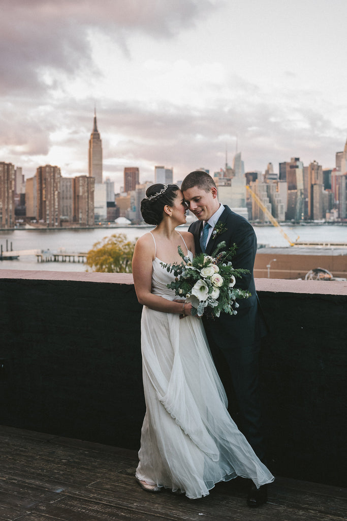 Winter wedding Brooklyn NY Greenpoint Loft pinecone ranunculus bud green brown silver Molly Oliver Flowers eco friendly sustainable December flowers first look couple portrait eucalyptus amaryllis cut flower kale ornamental cabbage silver bells Empire State Building