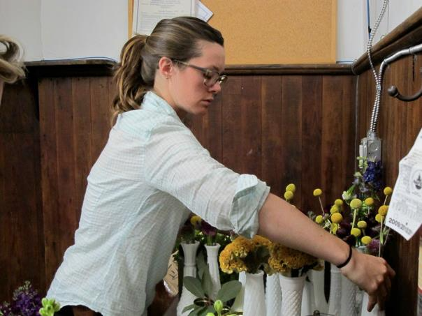 Molly Oliver arranging flowers in Nashville first wedding event Craspedia Yellow Celosia Milk glass