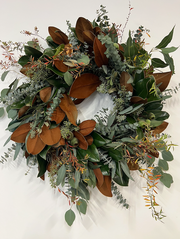 Decorative wreath with green and brown leaves on a white background
